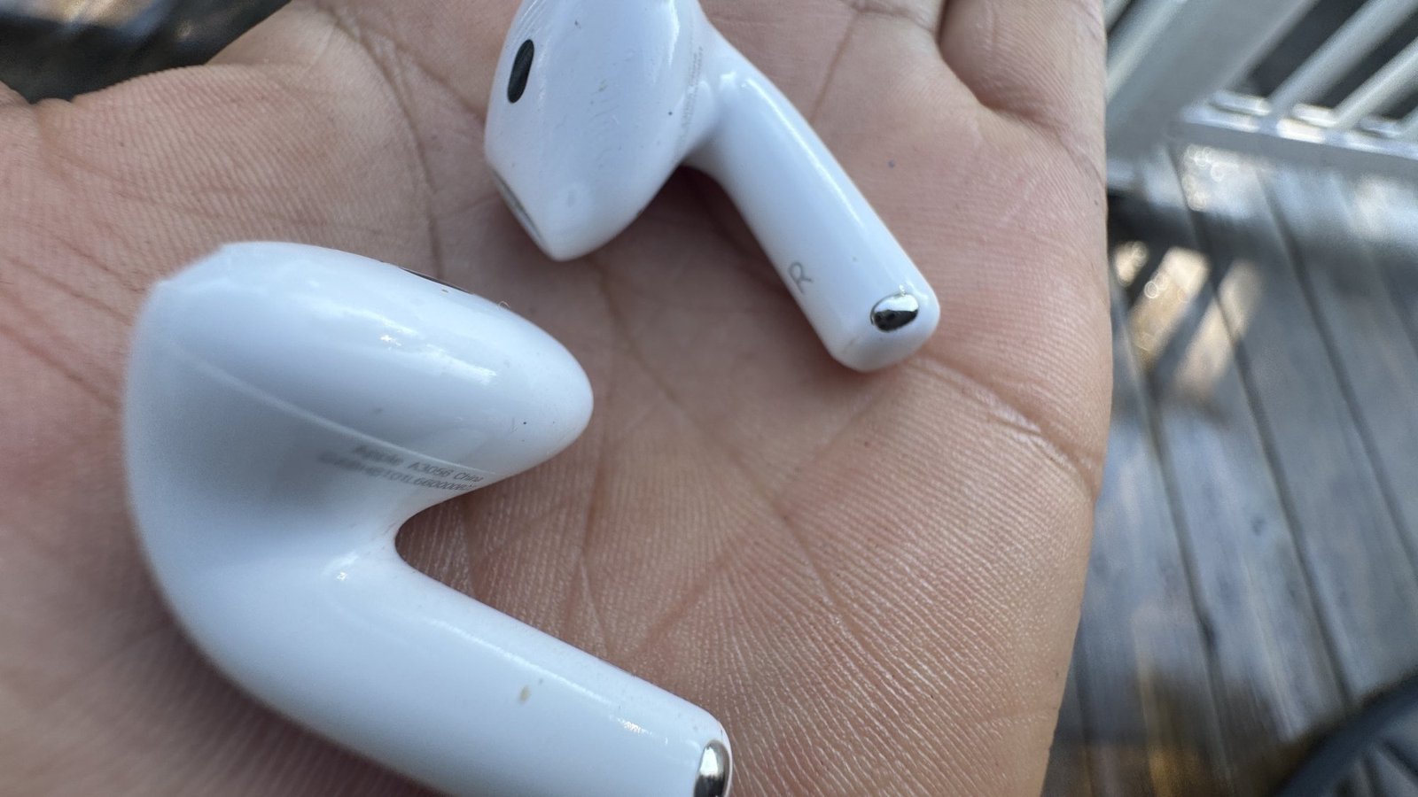 Woman holding the AirPods 4 on the palm of her hands