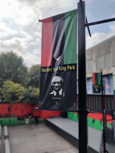 A red-black-and-green flag labeled Herbert Von King Park. 