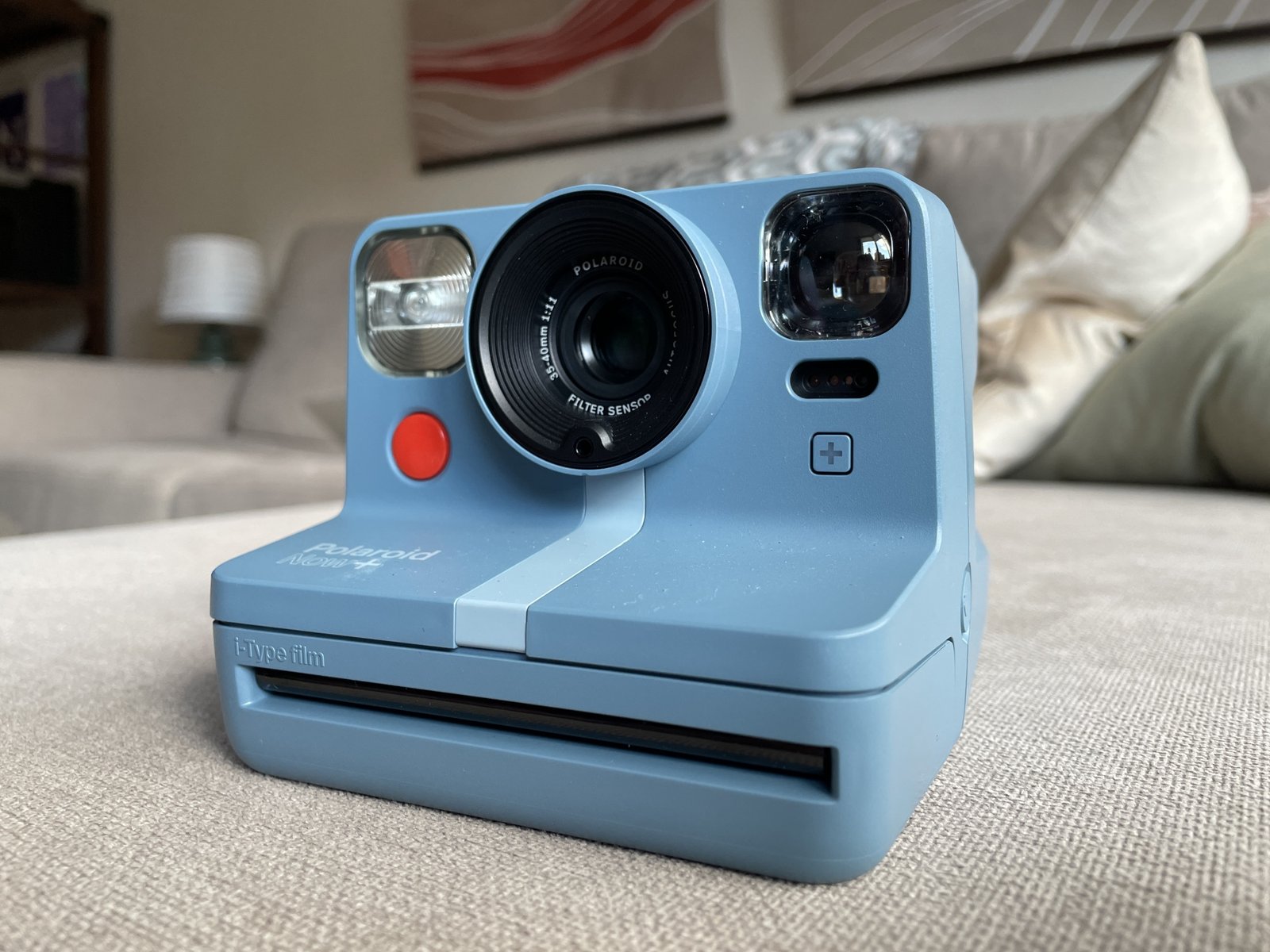 blue instant camera sitting on a couch